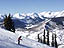 A skier enjoys a beautiful afternoon on Mt. Crested Butte, with the Elk Mountain Range in the background.